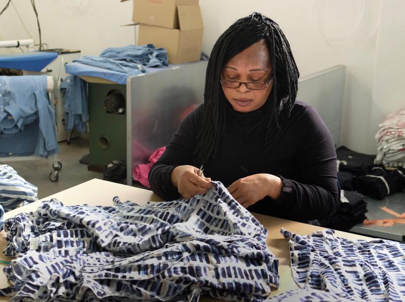 Ijeoma Maduekeputs the finishing touches on some clothing at Progetto Quid. ©Chris Welsch